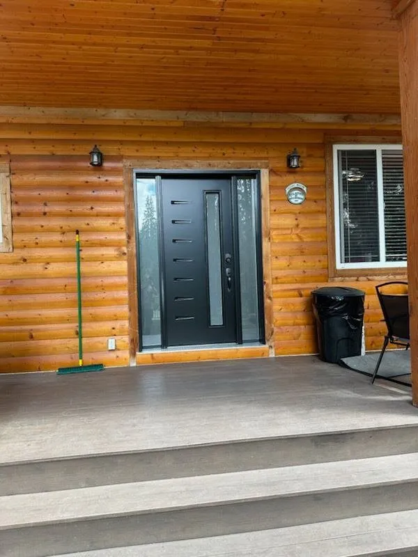 Black entry door on a log home
